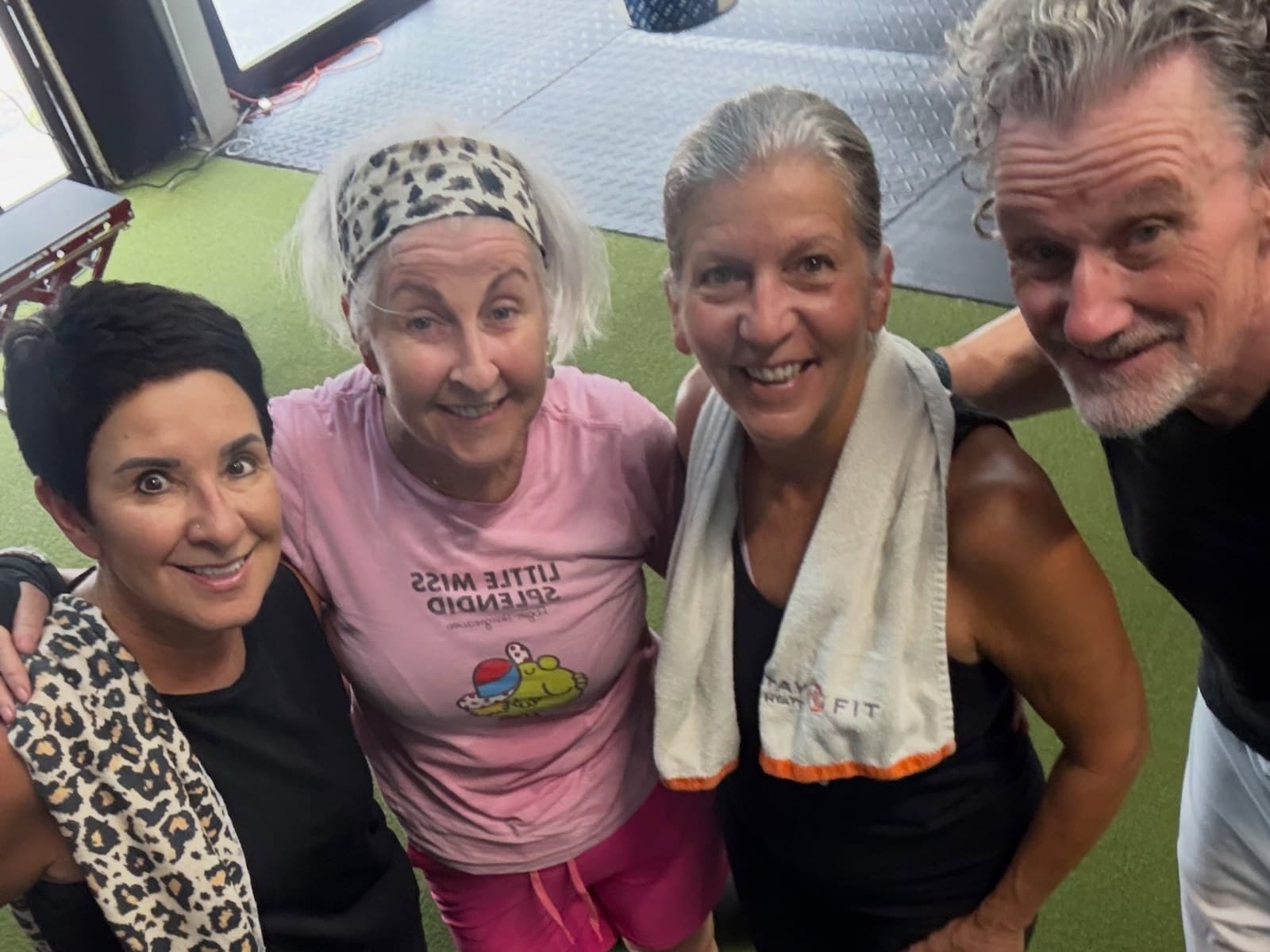 Four senior members together on the turf floor after class