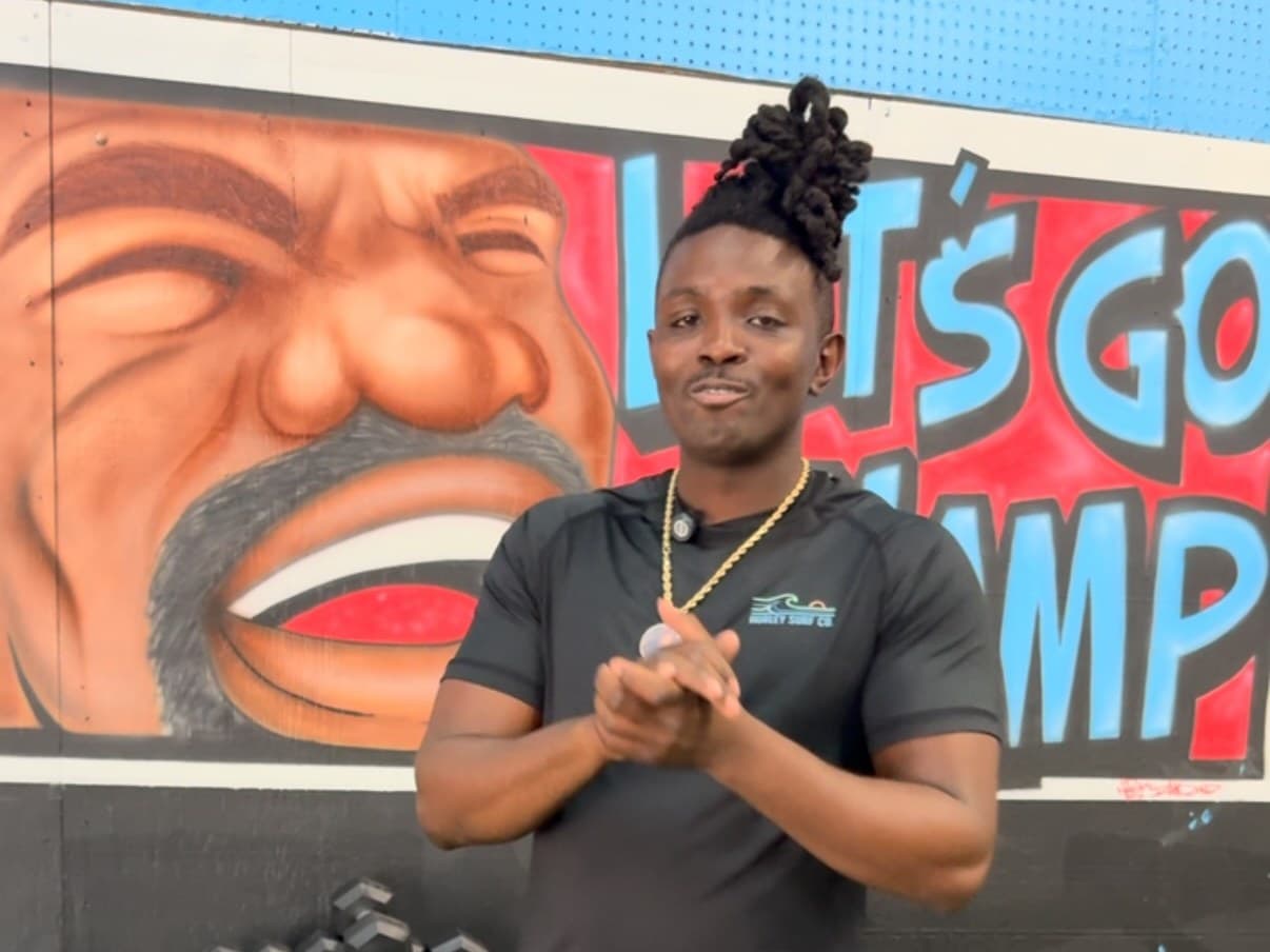 Coach in front of the LET'S GO CHAMP mural