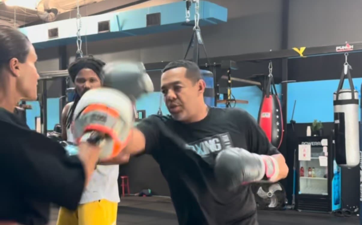 Coach working a mitt with a member on the gym floor
