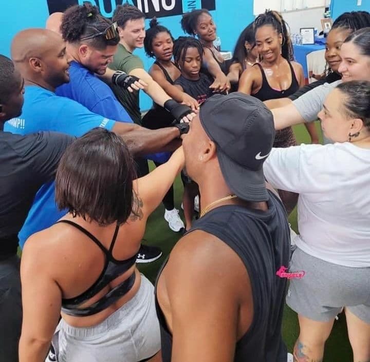 Members in a post-class huddle with hands stacked